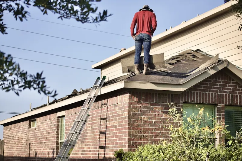 Professional roofer working on a residential roof in Anise